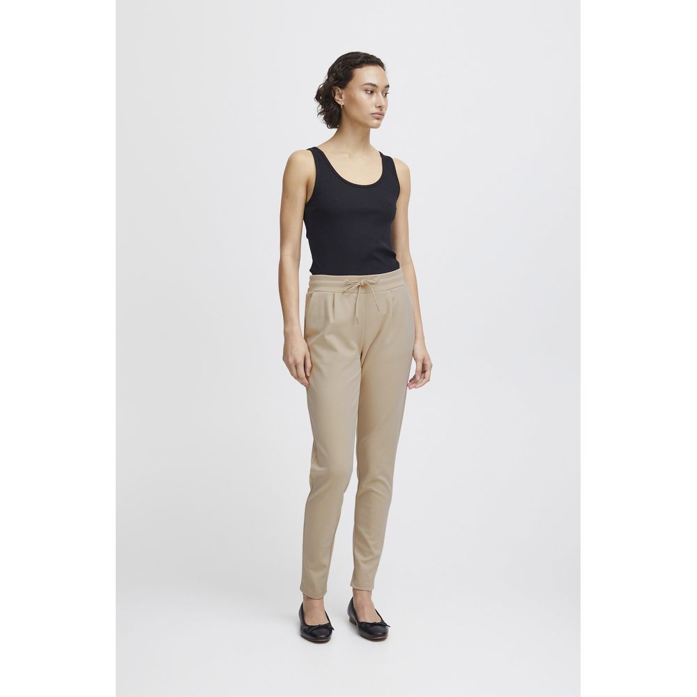 Woman modeling ICHI Beige Polyester Pants with elastic waistband and drawstring, showcasing slim fit and front pleats for modern style and comfort.