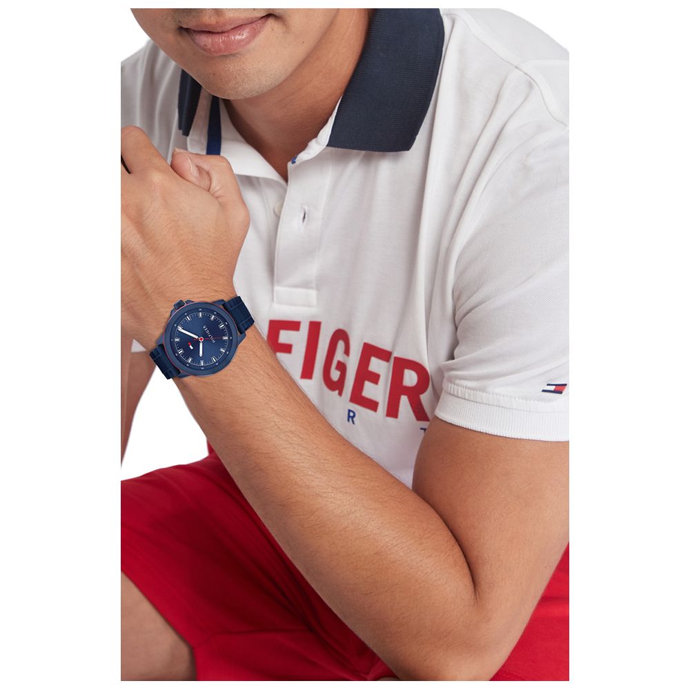 Gent wearing TOMMY HILFIGER Mod. 1792022 watch with blue dial, quartz movement, and 5 ATM water resistance, styled on wrist.