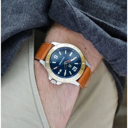 Gent wearing TOMMY HILFIGER Mod. 1710529 Quartz Analog Watch with brown strap, water-resistant, 46mm case, on wrist.