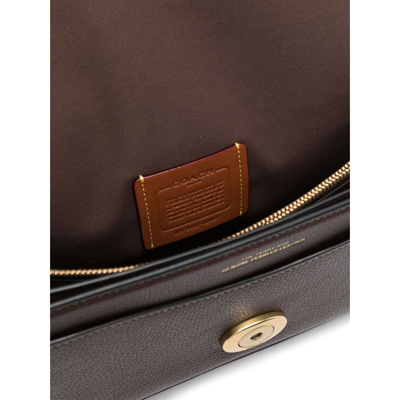 Interior view of Coach Tabby 26 leather shoulder bag with brown pebbled texture and logo plaque, showing zip-fastening pocket.