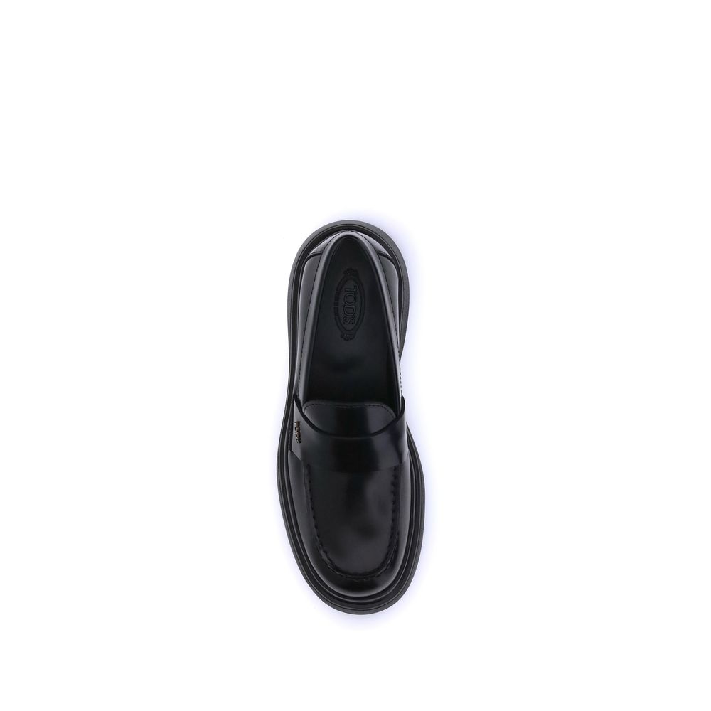 Alt Tag: Top view of Tod's Black Rubber Platform Loafers showcasing patent leather and rubber sole with a rounded toe design.