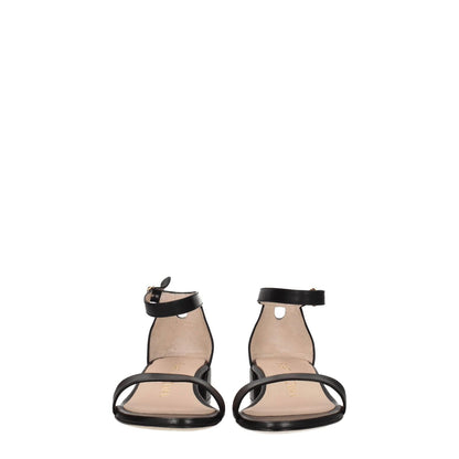 Front view of Stuart Weitzman Black Leather Flat Sandals with buckle closure and open toe design.