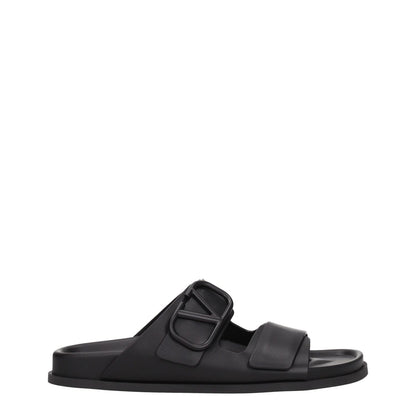 Valentino Garavani Black Leather Slippers with open toe and front logo, featuring a low flat heel and rubber sole, MPN S0G80UHE0NO.