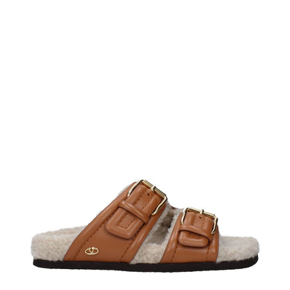Side view of Valentino Garavani Brown Leather Slippers with buckle closure, open toe design, and rubber sole for casual wear.