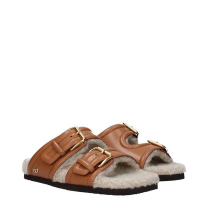 Valentino Garavani Brown Leather Slippers with buckles, open toe design, rubber sole, and low flat heel in casual style.