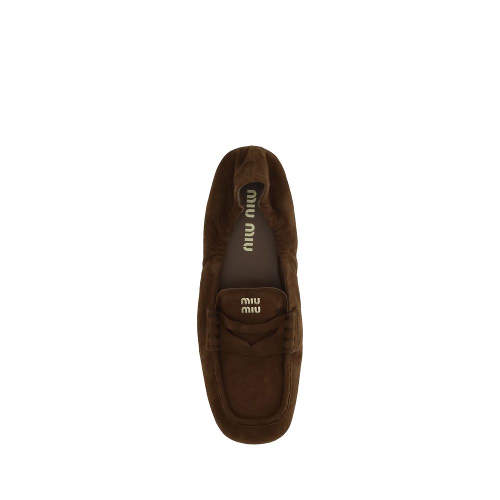 Top view of Miu Miu Brown Calf Leather Bos Taurus Slip-On Loafers showcasing the suede leather and embossed logo on the tongue.