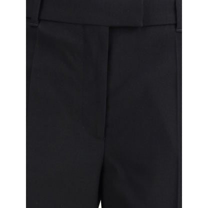 Close-up view of Alexander McQueen Black Wool Dress Pants with classic pleats, showcasing elegant tailoring details and back pocket flap.