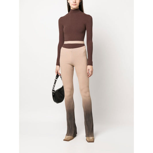 Model wearing ANDREĀDAMO Andrea Adamo Trousers Brown with ribbed design, high-waisted, ombré effect, and flared cut-out detailing.