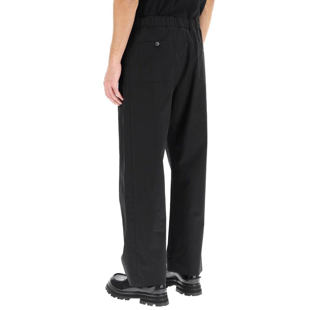 Back view of Alexander McQueen Black Cotton Casual Pants with elastic waist, two back pockets, and front zip closure, made in Italy.
