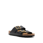 Birkenstock Double-strap leather sandals with black leather, logo-engraved buckles, perforated details, and gold-tone hardware.
