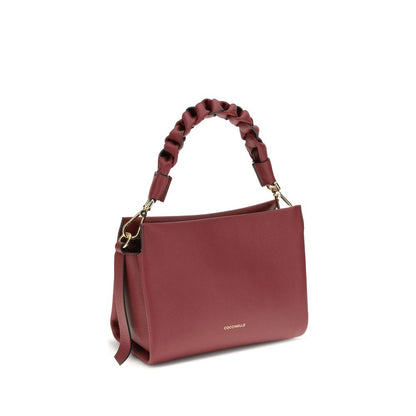 Coccinelle Bordeaux Calf Leather Bos Taurus Shoulder Bag with braided handle and removable strap, elegant garnet leather design.