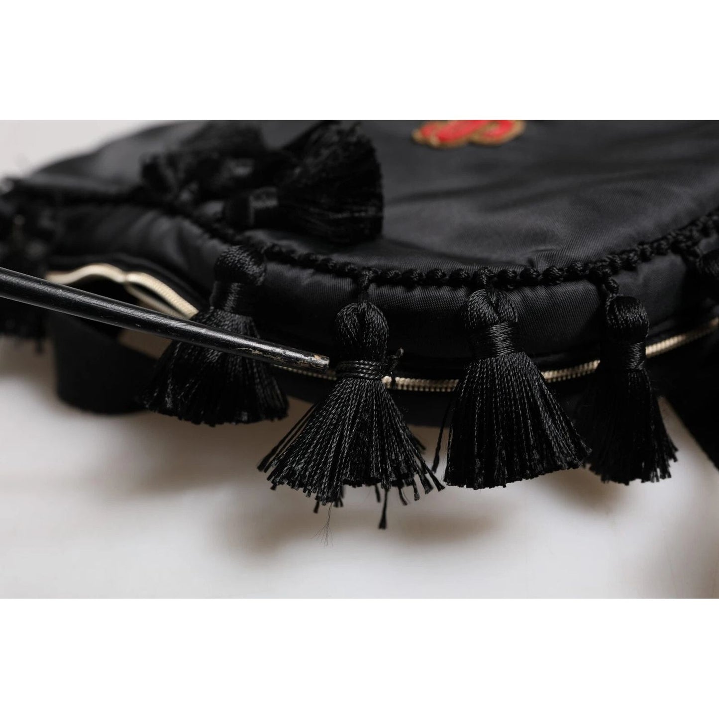 Close-up of Dolce & Gabbana Black Heart L'Amore Patch Embellished Kids Backpack with tassel details.