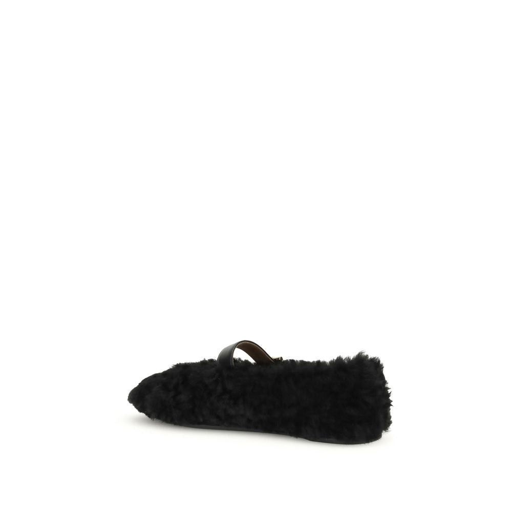 Ferragamo Black Fur Ballet Flats with Gancini buckle and curly shearling lining, side view on white background.