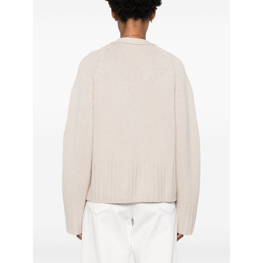 Back view of a SOFT GOAT Sweaters Ivory cashmere cardigan with ribbed trim and plunging V-neck, showcasing its light beige color and design details.