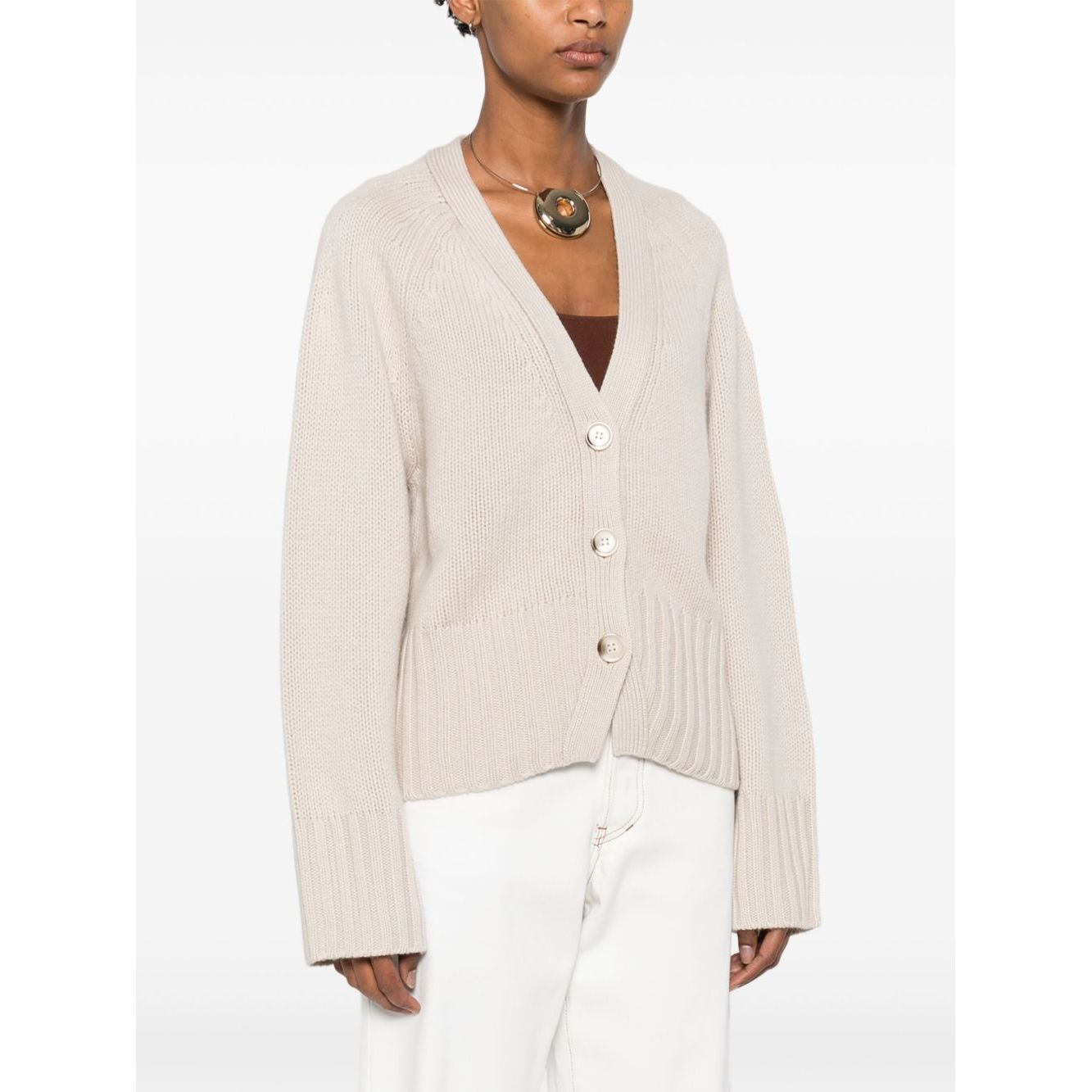 Model wearing SOFT GOAT Sweaters Ivory cashmere cardigan with V-neck, button fastening, and ribbed trim.
