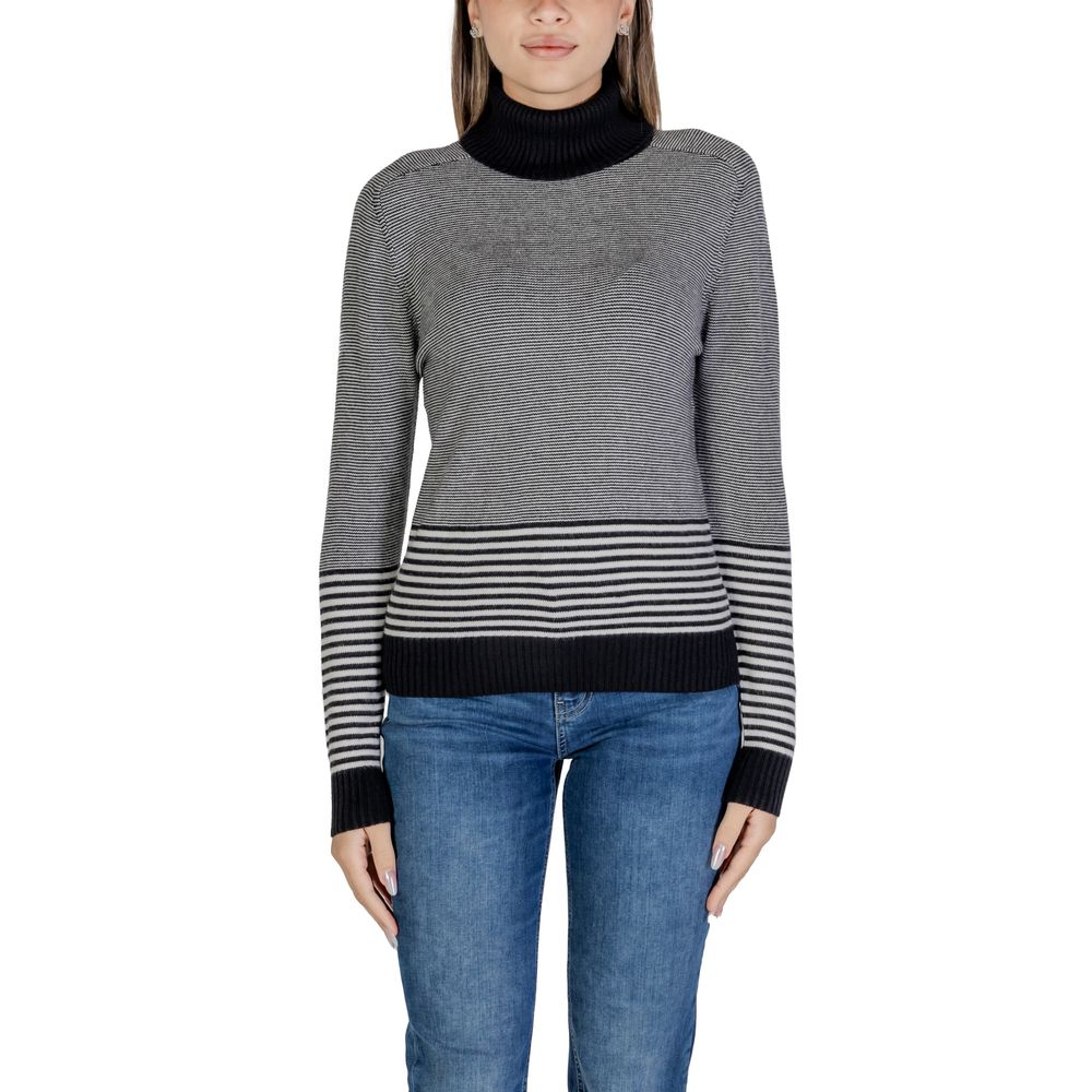 Woman wearing Sandro Ferrone Black And White Viscose Turtleneck sweater with striped pattern.