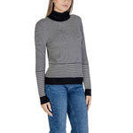 Woman wearing Sandro Ferrone Black And White Viscose Turtleneck with striped pattern and jeans