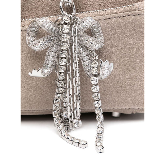 Close-up of silver-tone bow detailing on Self-Portrait suede baguette shoulder bag in grey with zip fastening and suede texture.
