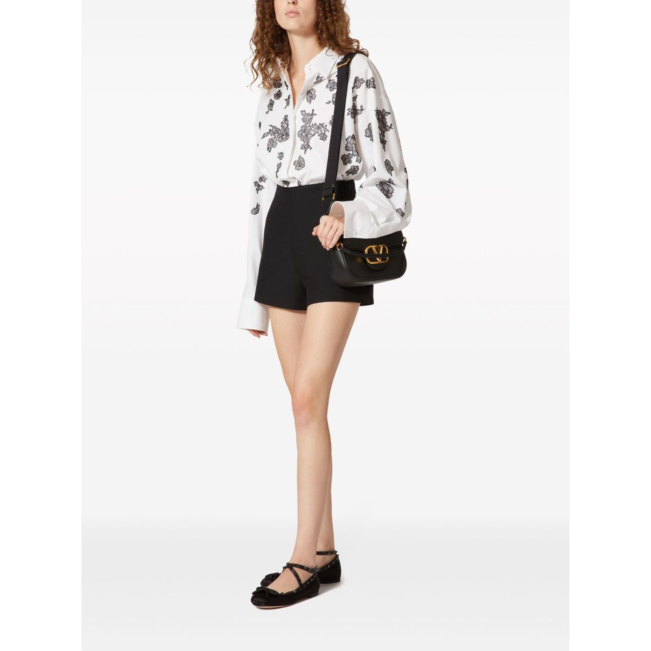 Model wearing Valentino Garavani Alltime Grainy Calfskin Shoulder Bag with adjustable strap and VLogo on a white background.